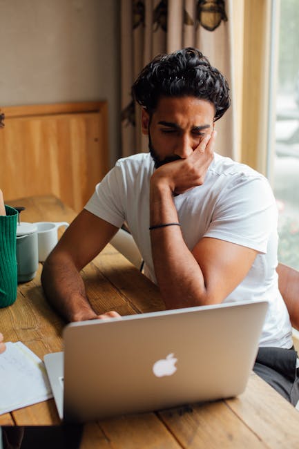 person looking tired at computer screen with strained eyes in office environment